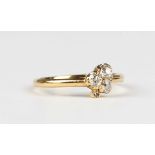 A gold and diamond ring in a trefoil shaped design, mounted with cushion cut diamonds, unmarked,