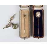 A gold topped stickpin, mounted with a cushion cut sapphire, a shell cameo stickpin, carved as a