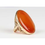 A 9ct gold ring, collet set with a large oval cornelian, Sheffield 1990, weight 20.5g, dimensions of