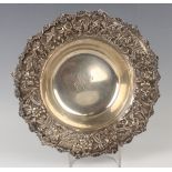 An early 20th century American sterling circular bowl, the outswept rim decorated in relief with