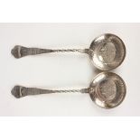 A pair of Victorian silver serving spoons, each circular bowl engraved with fruit and leaves, framed