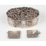 An Edwardian silver oval box, the cover pierced with stems of mistletoe, the sides embossed with a