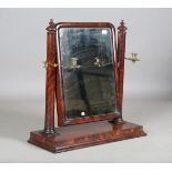 An early Victorian figured mahogany dressing table mirror, fitted with two brass candle holders,