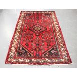 A Hamadan rug, North-west Persia, late 20th century, the red field with a lozenge medallion,