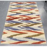A contemporary design rug, modern, the ivory field with geometric polychrome bands, 180cm x 125cm.
