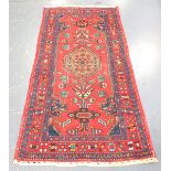 A Hamadan rug, North-west Persia, mid-20th century, the red field with a stepped medallion and