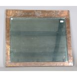 A large early 20th century Arts and Crafts copper mounted wall mirror, in the manner of Liberty &