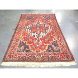 A Hamadan rug, North-west Persia, mid-20th century, the red field with a large medallion, within a