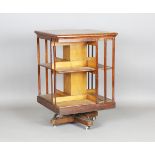 A late Victorian oak revolving library bookcase with slatted sides and iron mounted base, height