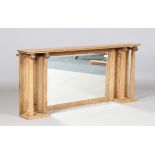 An Edwardian Arts and Crafts oak overmantel mirror, the bevelled glass flanked by carved panels