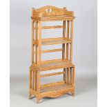 An early 20th century Arts and Crafts oak open bookcase by Wylie & Lochhead, the pierced gallery