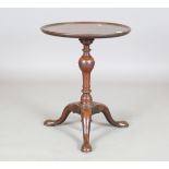 A George II mahogany wine table, the dished circular top above a baluster stem and tripod feet,
