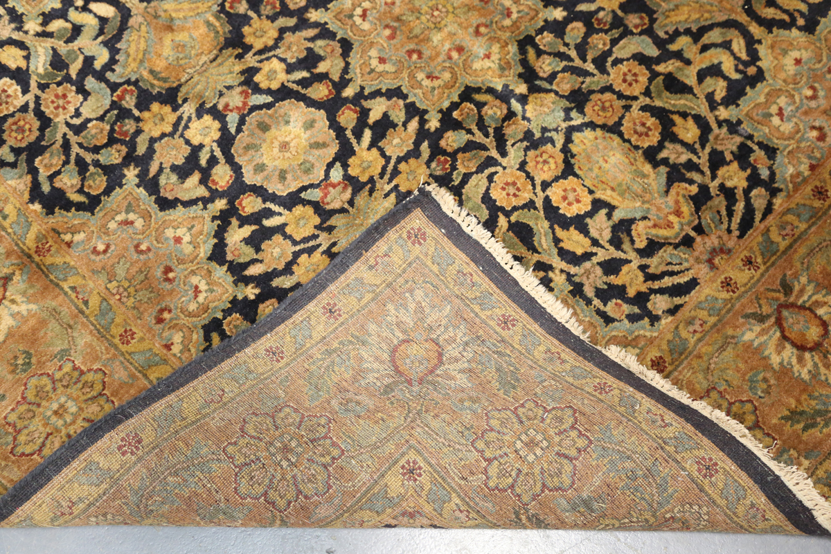 An Indian carpet, late 20th century, the charcoal field with overall palmettes, flowerheads and - Image 2 of 6