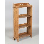 An early 20th century Arts and Crafts oak open bookcase, in the manner of Liberty & Co, the four