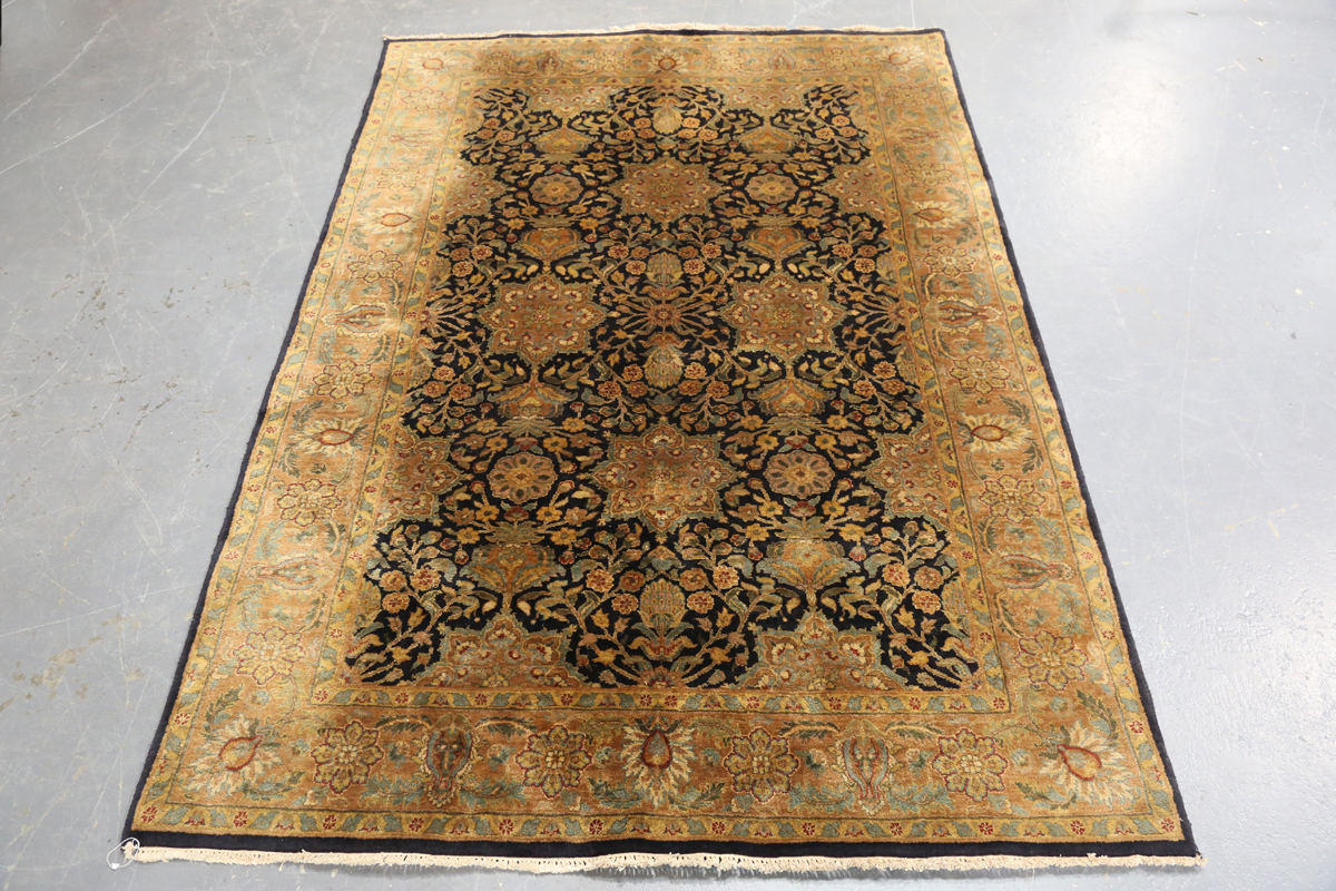 An Indian carpet, late 20th century, the charcoal field with overall palmettes, flowerheads and