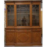 An early 20th century oak breakfront bookcase cabinet, the dentil pediment above astragal glazed