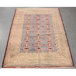 A Turkestan style rug, late 20th century, the blue field with columns of guls, within a multiple
