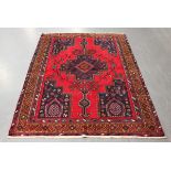 A Hamadan rug, North-west Persia, late 20th century, the red field with a shaped medallion, within a