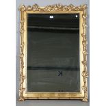 A modern gilt composition rectangular wall mirror with a foliate trailing frame, 111cm x 78cm.