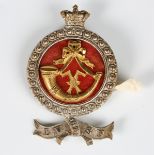 An unusual Victorian silvered metal helmet plate badge with crown above a gilt slung bugle over a