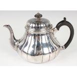 A Victorian silver circular reeded low-bellied teapot, the reeded domed hinged lid with turned