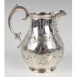 An early Victorian silver baluster cream jug with engraved decoration, flanked by a stylized scallop
