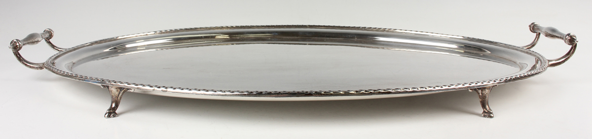 A George V silver oval tray with raised rim flanked by two scroll handles, on scroll legs, London - Image 3 of 3