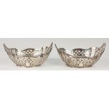 A pair of Edwardian silver oval bonbon dishes, each with pierced sides beneath a shaped reeded