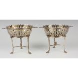 A pair of Edwardian silver circular bonbon dishes and stands, each with pierced sides flanked by