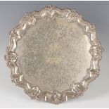 A late Victorian silver circular salver, inscription engraved, framed by floral and foliate