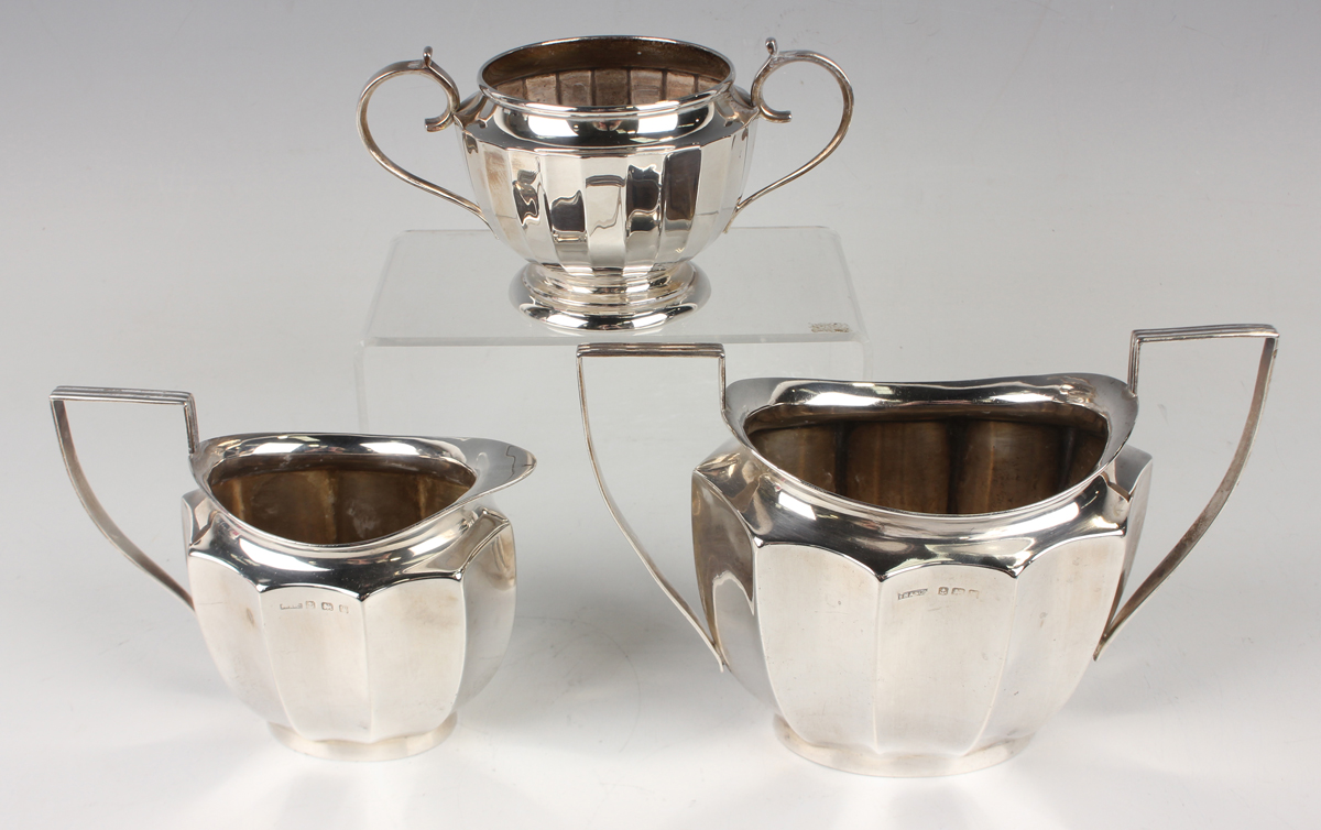 A George VI silver two-handled sugar bowl and matching milk jug of oval faceted form, Birmingham