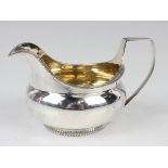 A George III silver milk jug of squat globular form with gadrooned rims, London 1804 by Robert &