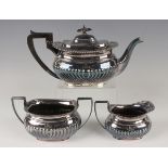 A George V silver three-piece tea set of half-reeded cushion form, comprising teapot, two-handled