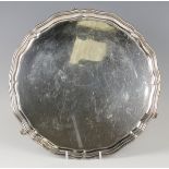 A George VI silver circular salver with piecrust rim, raised on scroll legs, Chester 1937 by S.