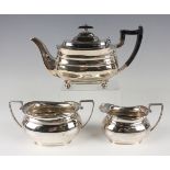 A George V silver harlequin three-piece tea set of cushion form, comprising teapot, Sheffield 1936