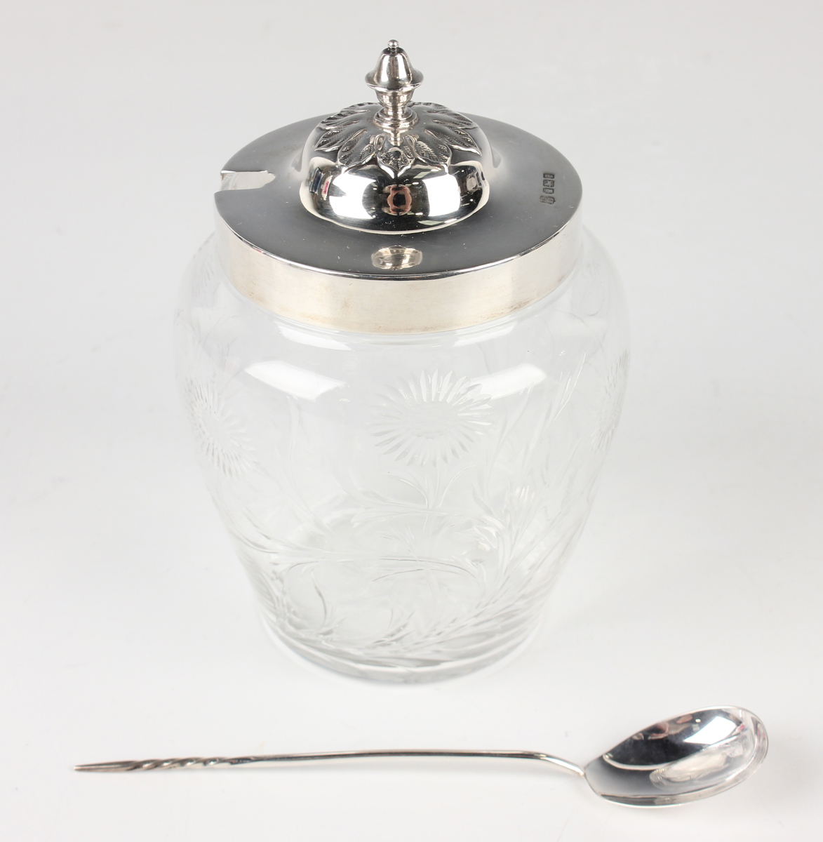 A George V silver lidded and Stourbridge glass preserve jar, the foliate capped lid with knop finial