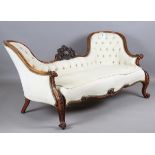 A mid-Victorian walnut showframe conversation settee, the frame finely carved with foliate