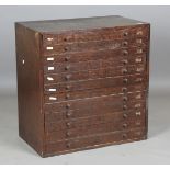 An early 20th century oak folio chest of twelve drawers, each drawer with two anodized brass