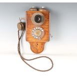 An early 20th century oak cased wall-mounted telephone, height 33cm.Buyer’s Premium 29.4% (including