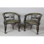 A pair of Victorian carved and stained oak tub back elbow chairs with lion's mask handrests and claw