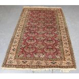 An Indian rug, mid-20th century, the puce field with overall boteh sprays, within an ivory