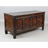 An early 18th century oak panelled coffer, the front with carved decoration, height 66cm, width