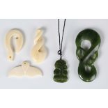 A group of five Maori carved pendants, including a Taniwha, length 7.5cm, a Hei-Tiki and three