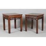 A pair of 19th century Chinese hardwood lamp tables, the square tops above pierced friezes and block