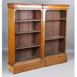 A late Victorian oak open fronted bookcase, the moulded pediment above open shelves, on a plinth