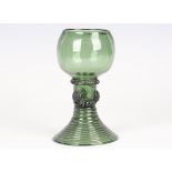 An English green glass roemer, late 18th century, the rounded cup shaped bowl raised on a hollow