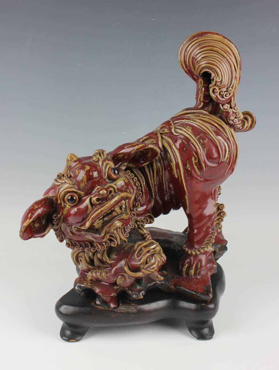 A Chinese Shiwan pottery sang-de-boeuf glazed figure group of a Buddhistic lion and playful cub,