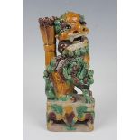 A Chinese sancai enamelled biscuit porcelain Buddhistic lion jostick holder, Kangxi period, modelled