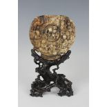 A Chinese carved soapstone plaque with carved hardwood stand, early 20th century, the circular