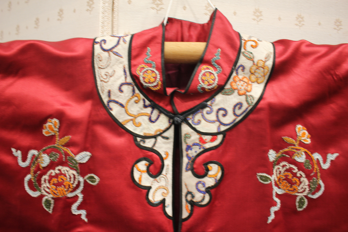 A Chinese red silk embroidered coat/robe, 20th century, worked in coloured threads with figure and - Image 16 of 19
